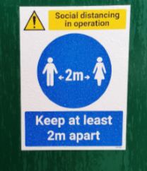 Social distancing sign saying 'Keep at least two meters apart'.